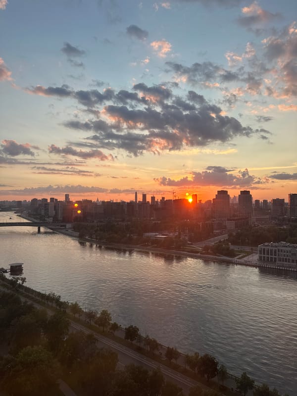 Moscow River at golden hour, city skyline reflecting the sunset
