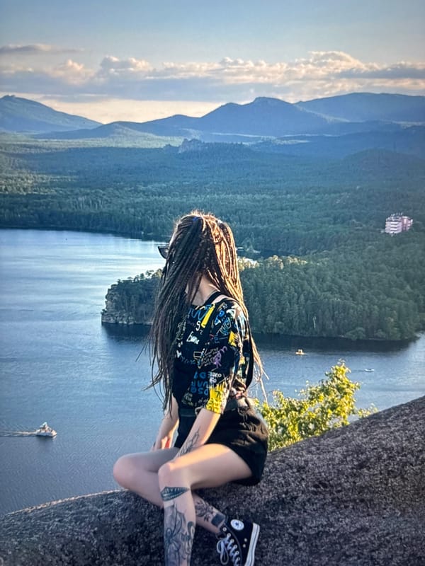 Sitting on rocks above a forested lake in rural Russia