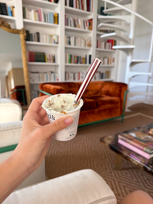 Person enjoys granola yogurt in book-filled room