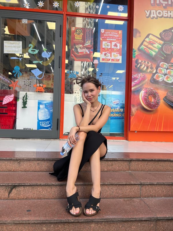 Woman sits peacefully on store steps in Vietnam