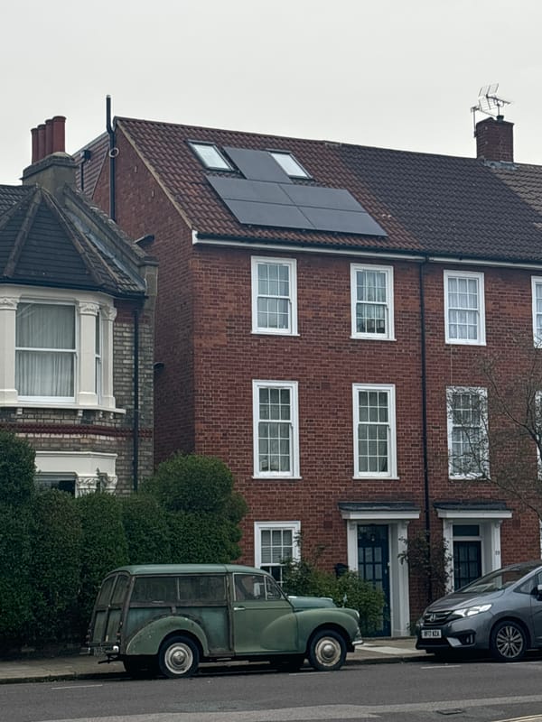 London residential street with solar-paneled brick buildings observed