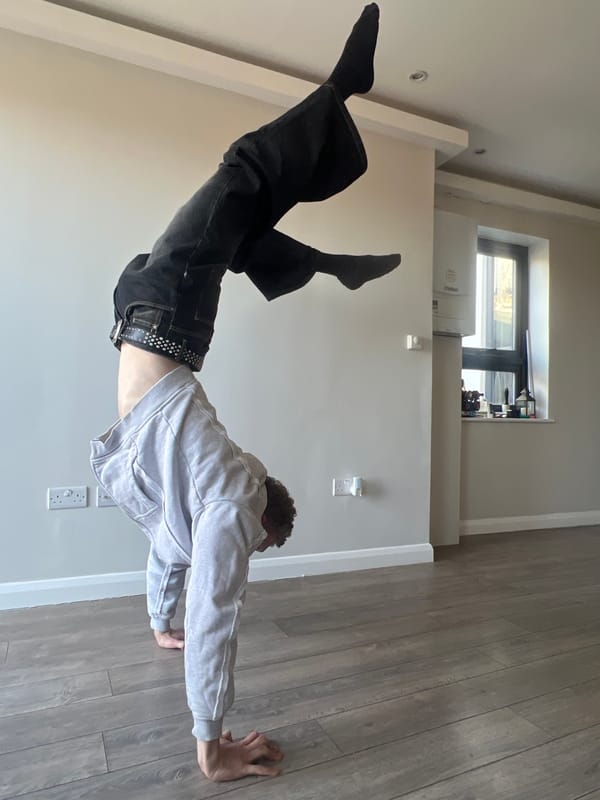 Person performs yoga pose on hardwood floor in London