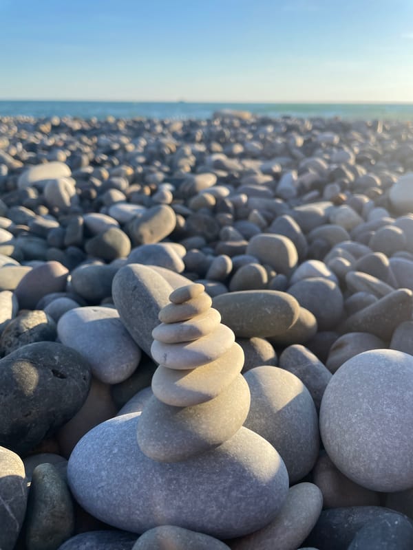 Afternoon on a pebble beach, with glimpses of a nearby coastal city