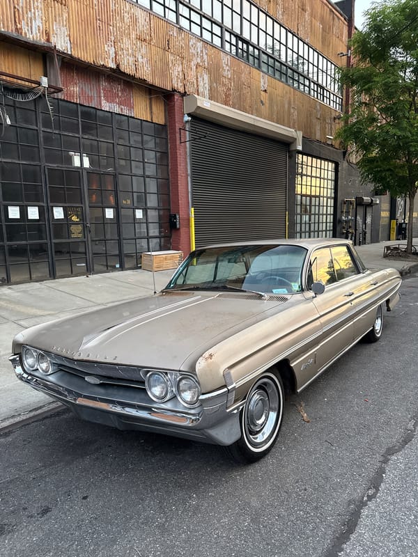 Vintage Gold Oldsmobile Parked Outside Industrial Building in NYC