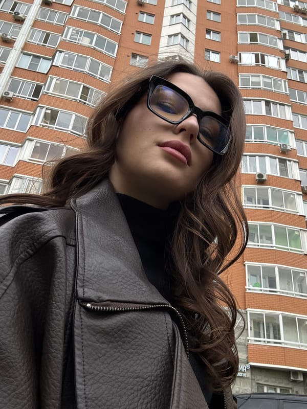 Woman takes selfies outside brick building in Vnukovo