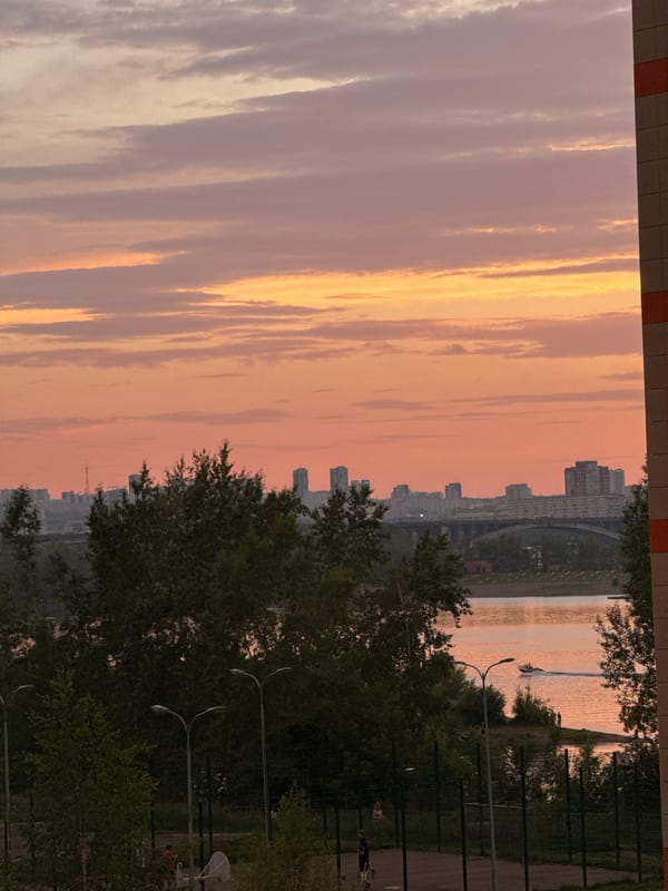 Krasnoyarsk at golden hour, river and skyline under a summer sunset