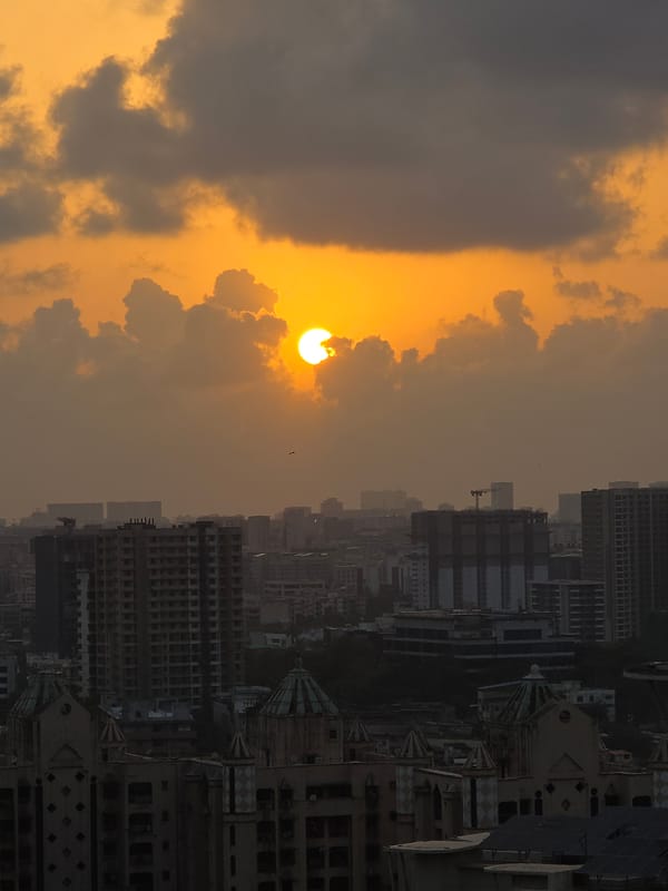 Sunset observed over Mumbai cityscape amid cloudy skies