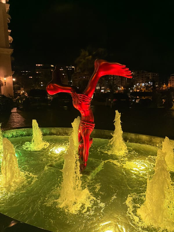 Albanian nighttime scenes feature fountain sculpture and resort television display