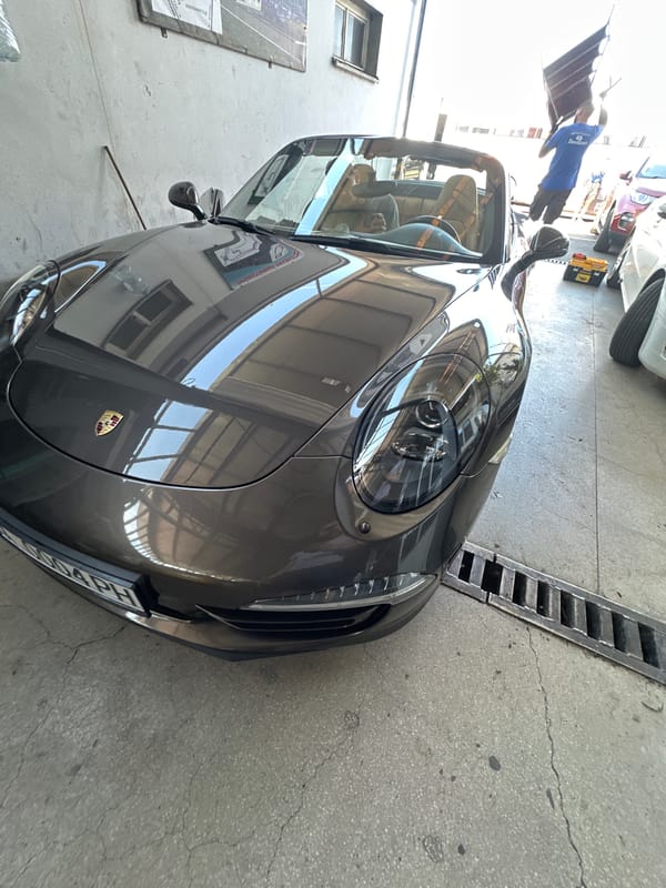 Dark gray Porsche with Bulgarian plates at an automotive facility