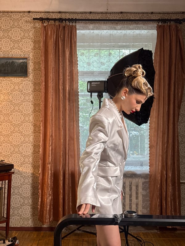 Woman poses for portrait in white satin and pearls