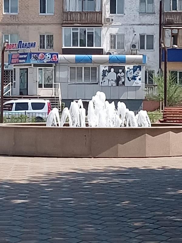 Fountain and mosque anchor a July morning in Rudny