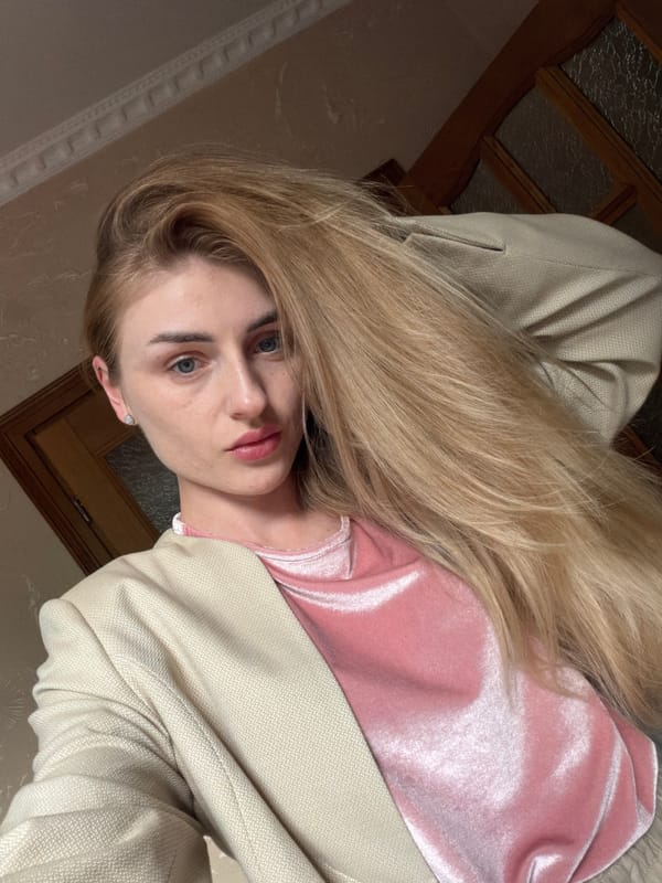 Mirror selfie session in a beige blazer and pink top