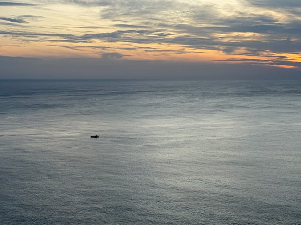 Lone fishing boat at dusk on the Đà Nẵng coast