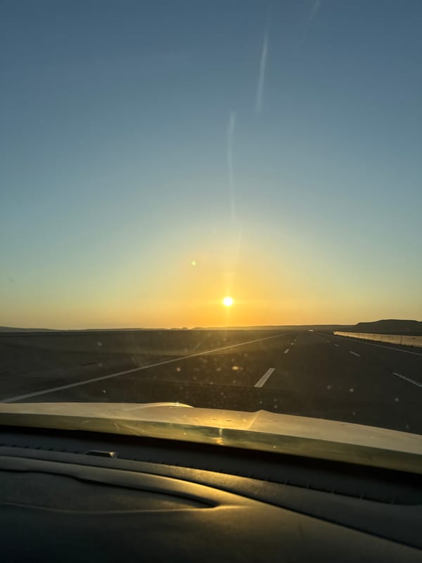 Highway sunset rolling through open desert landscape