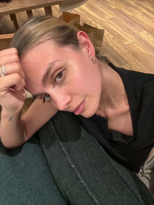 Person rests on wooden floor with shopping bag nearby