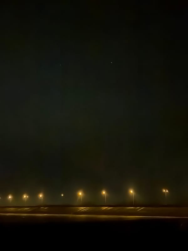 Streetlights illuminate evening roadway in Noviy, Russia