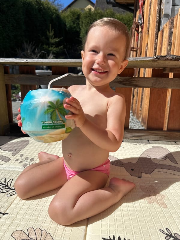 Child enjoys coconut drink on outdoor deck in Wisła