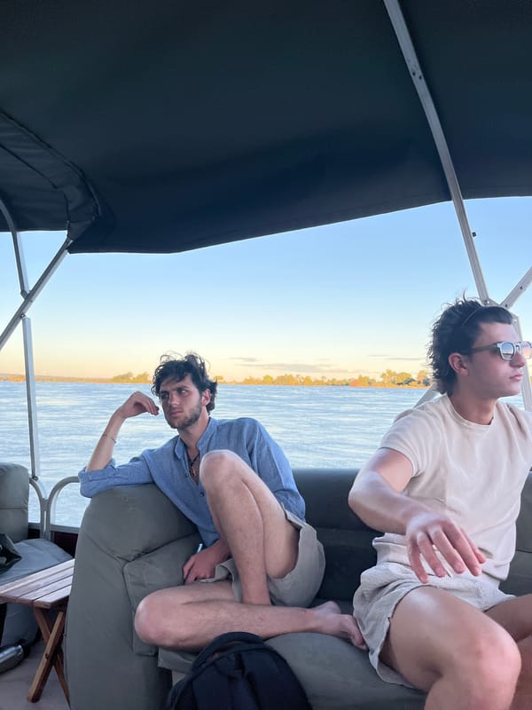 Men enjoy boat leisure time during Zambezi River sunset