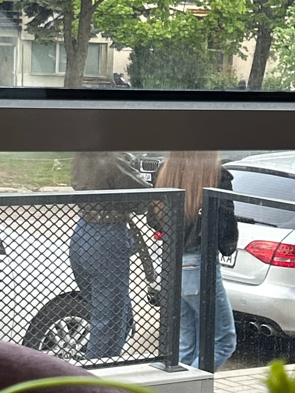 Person uses smartphone at Sofia cafe during sunset