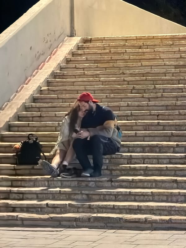 Two people embrace beside wall in Tel Aviv