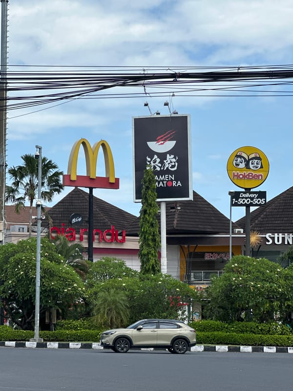 Early morning scooter traffic observed near McDonald's in Denpasar