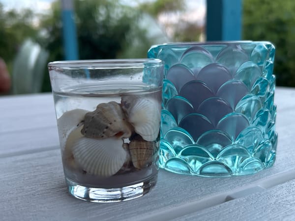 Coastal-themed glass décor on a white wooden surface