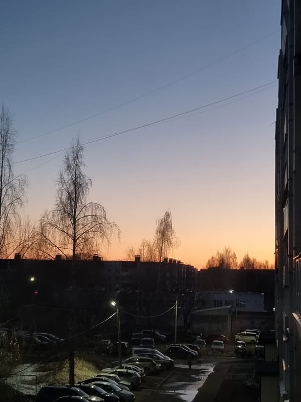 Twilight gradient sky photographed between apartment buildings in Chaikovsky