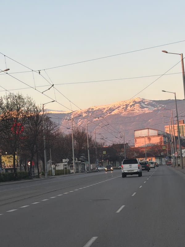 Morning street scene documented in Sofia with mountain backdrop