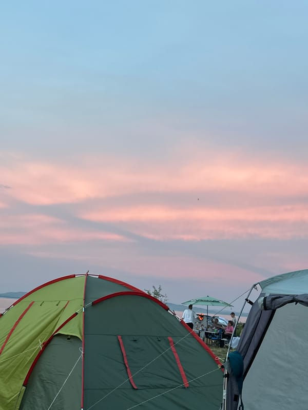 Lakeside campsite in rural Russia, tents up and fire going