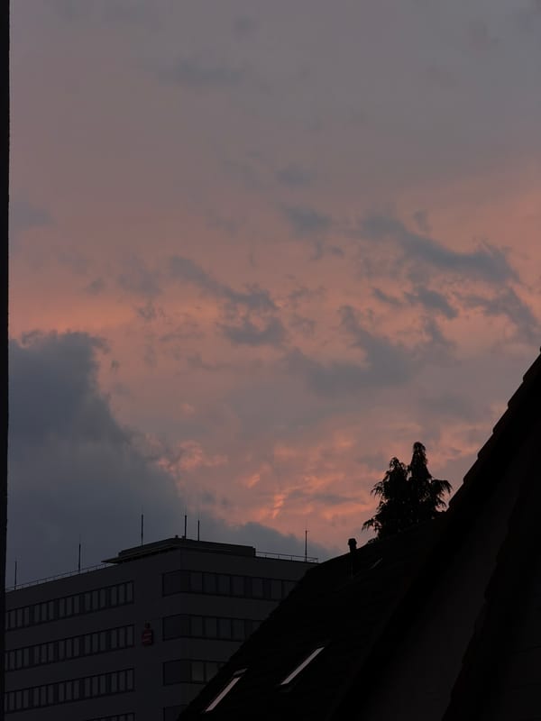 Dusk settles over a half-timbered European town under dramatic skies
