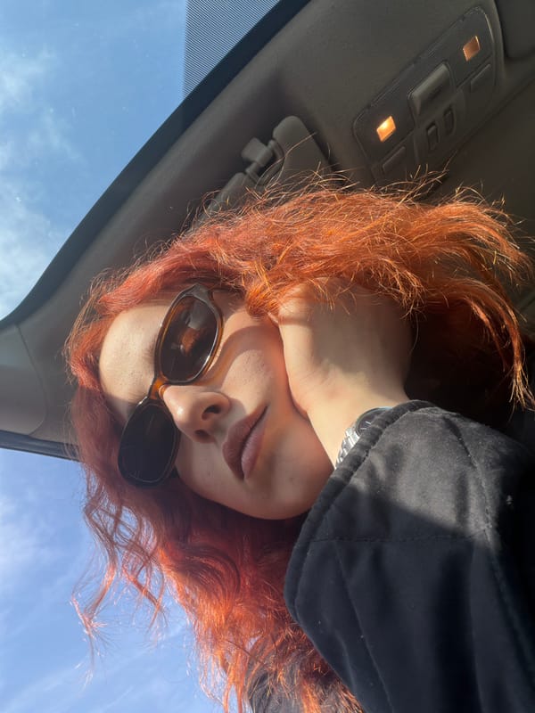 Person with red hair photographed inside car in Tbilisi
