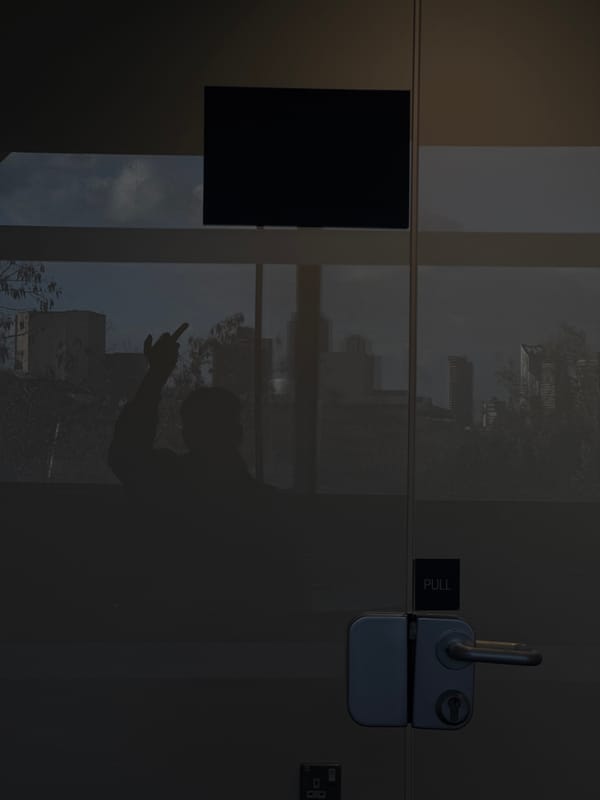 Person's reflection caught in London glass door with cityscape