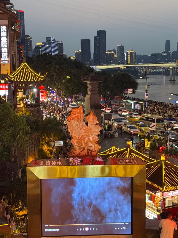 Crowds gather in illuminated Yuzhong District at dusk