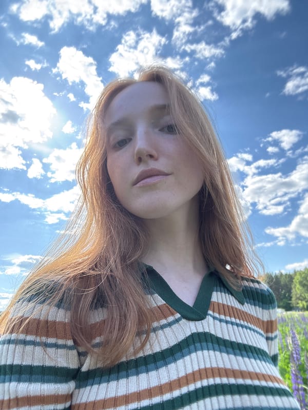 Woman photographs herself in lupine field in Chaikovsky, Russia