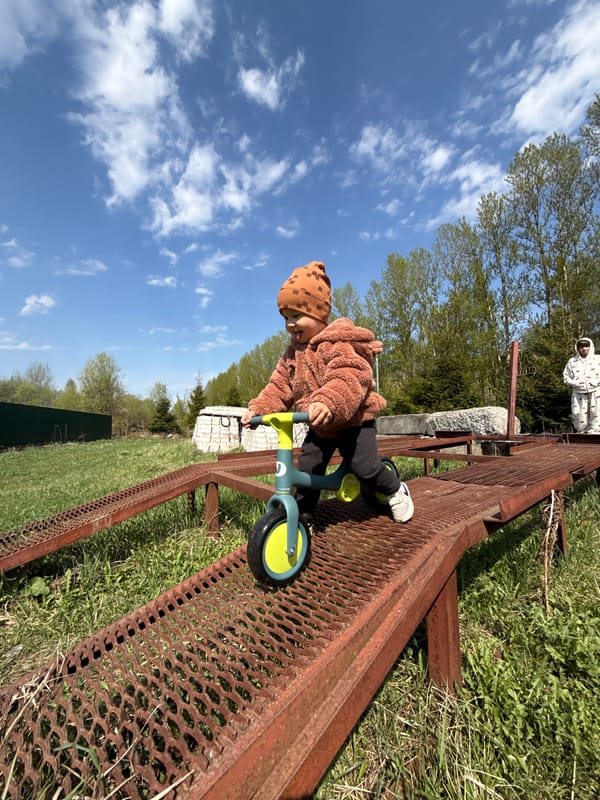 Child rides balance bike in Rusanovo park area
