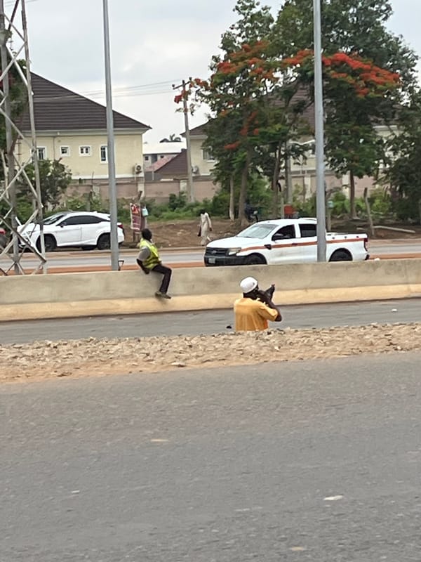 Two vehicles, individuals observed roadside in Abuja, Nigeria