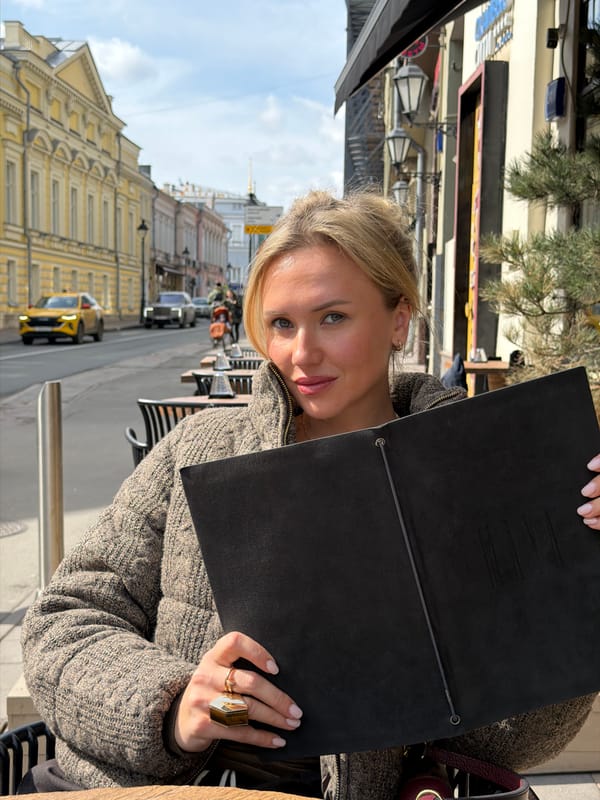 Woman reads menu at Moscow outdoor cafe