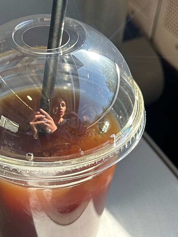 Woman drinks iced coffee on train in Tunbridge Wells