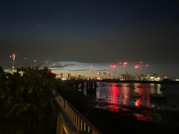 Canary Wharf skyline glowing across the Thames at night