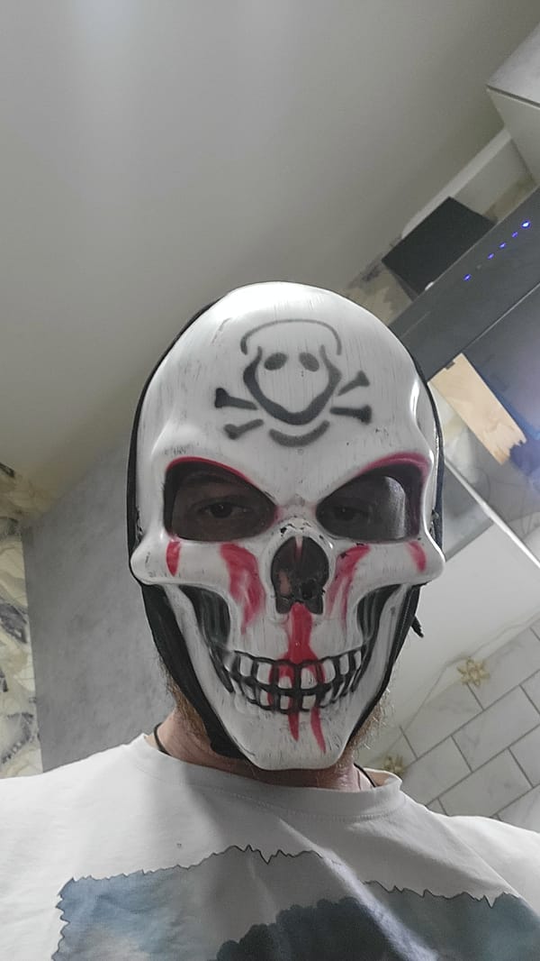 Masked Individual Spotted Near Lit Sports Field at Night