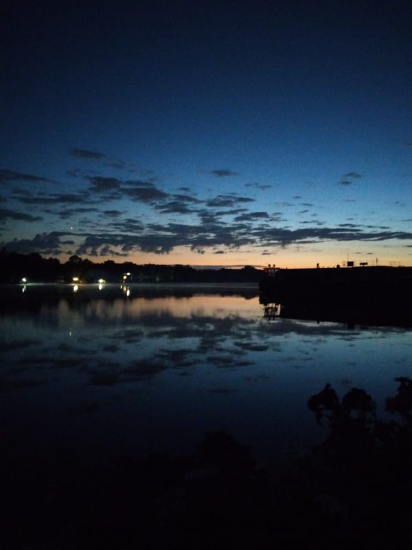 Twilight settling over a Kyiv waterfront, July 2026