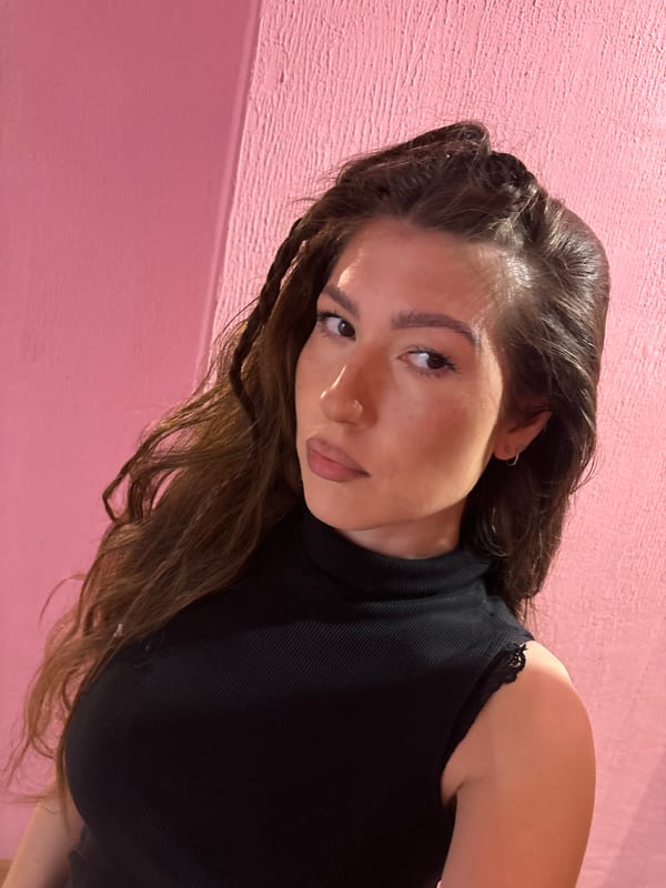 Woman takes early morning selfies against pink wall in Kazan