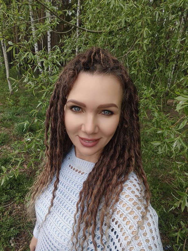 Woman takes selfies by waterside in blue sweater