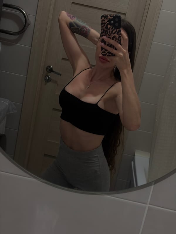 Woman documents skincare routine in bathroom mirror selfies