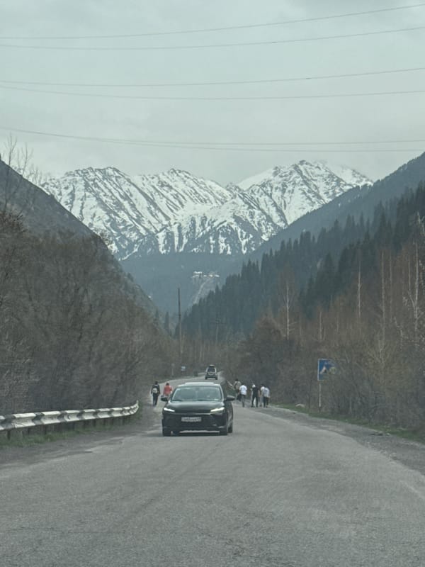 Woman drives through mountain valley near Almaty, Kazakhstan