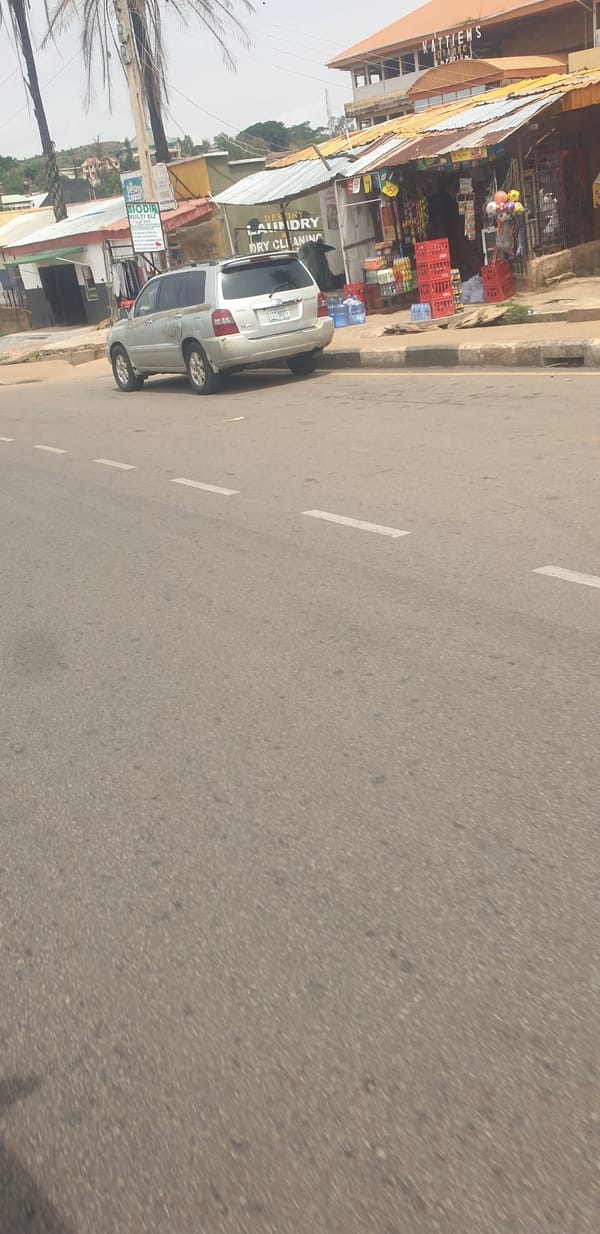 Street activity documented in Jos, Nigeria with parked SUV