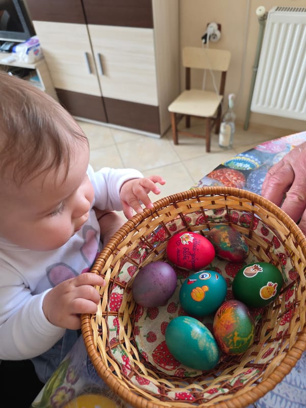Baby reaches for Easter eggs in Bulgarian apartment complex