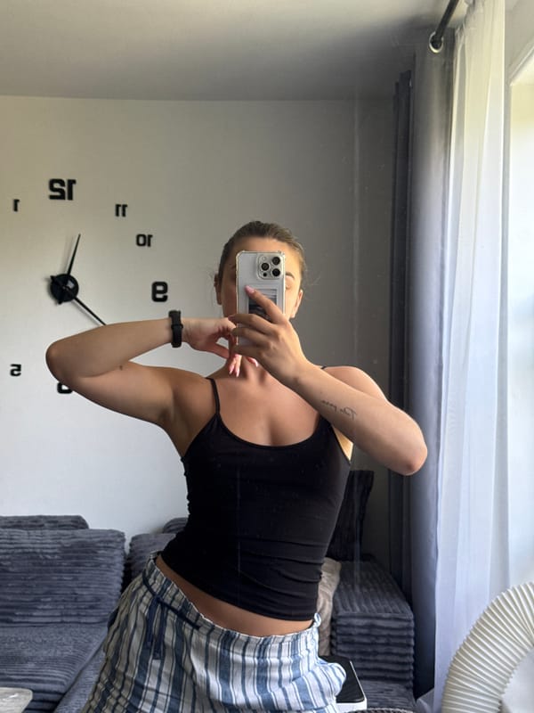 Mirror selfie in a New York apartment with a fire escape view
