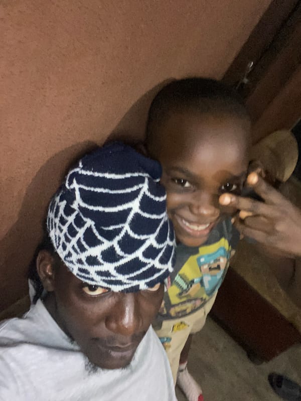 Child and adult share playful moments in Alagba home