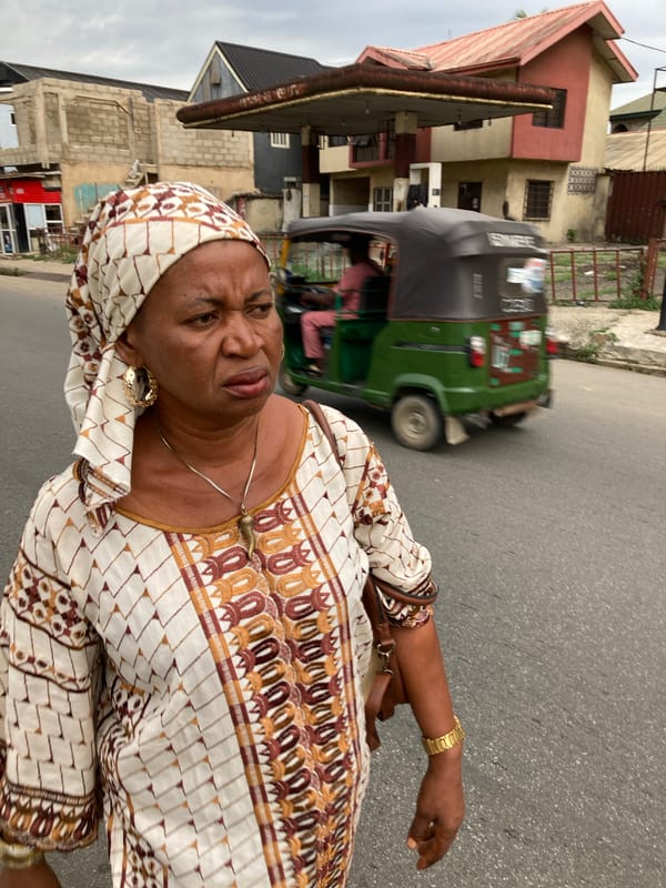 Woman in traditional dress walks street in Umuode, Nigeria